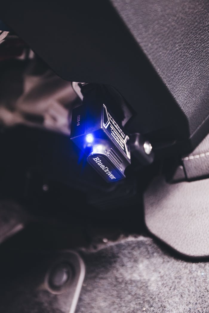 A detailed close-up of a BlueDriver Bluetooth code reader plugged into a vehicle.